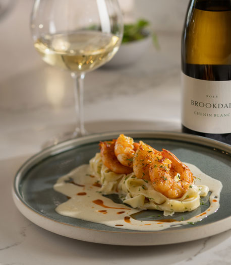 Brookdale Chenin Blanc wine bottle presented with creamy fish dish